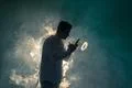 The man smoke an electronic cigarette with a ring on the dark background Photo