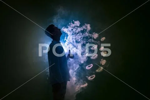 The man smoke an electronic cigarette with a ring against the background of.. Stock Photos