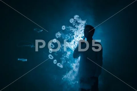 The man smoke an electronic cigarette with a ring against the background of.. Stock Photos