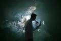 The man smoke an electronic cigarette with a ring on the dark background Photo