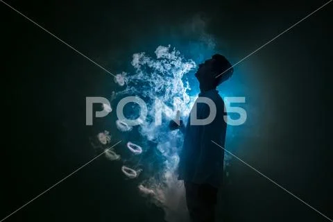 The man smoke an electronic cigarette with a ring against the background of.. Stock Photos