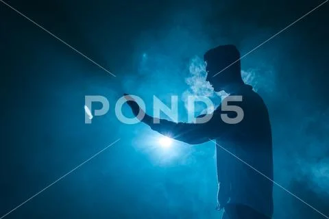 The man smoke an electronic cigarette with a ring on the blue background Stock Photos