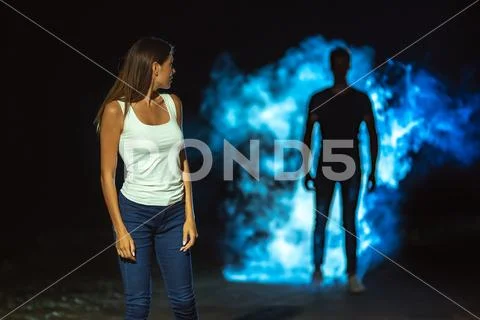 The man in smoke following the woman in the dark street Stock Photos
