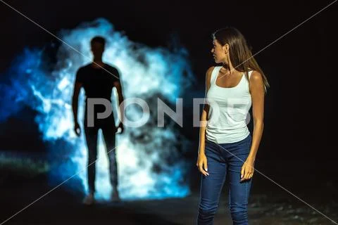 The man in smoke following the woman in the dark street Stock Photos