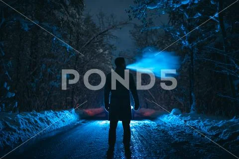 The man smoke on the snowy road in the forest. evening night time Stock Photos
