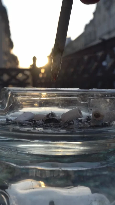 Man smokes and puts out the stub of a cigarette on an ashtray Stock Footage 331120125