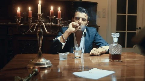 A man smokes a cigar at the table Stock Footage 87333026
