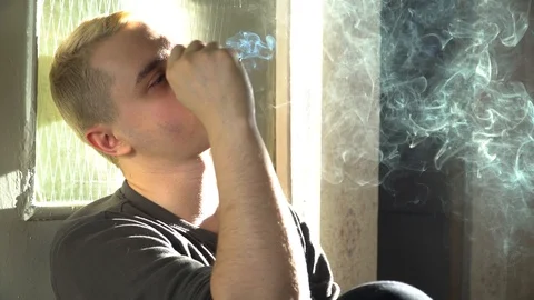 A man smokes a cigarette and drinks whiskey 库存影片 86044954