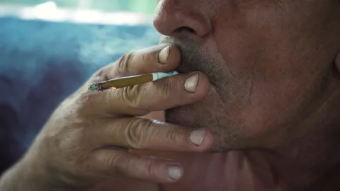 A man smokes a cigarette between work. Close-up. A lot of smoke. Smoking is Stock Footage 228454950