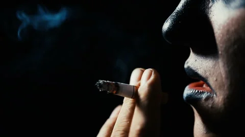 The man smokes a cigarette on a black background. Stock Footage 66910877