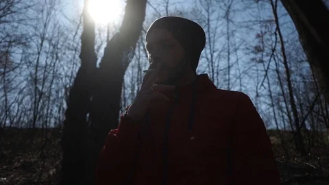 A man smokes a cigarette in the forest Stock Footage 126358829