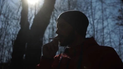 A man smokes a cigarette in the forest.Close up Stock Footage 126359027