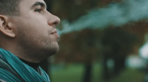 Man smokes a cigarette on the street 스톡 동영상 68196434