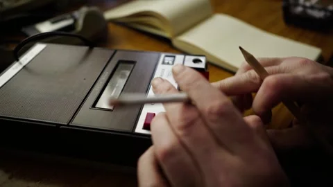 Man Smokes Cigarette While Replaying Testimony Tape and Writing Notes Video stock 302292133