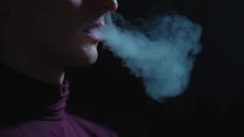 Man smokes an electronic cigarette in the dark. Vape. Stock Footage 236254691