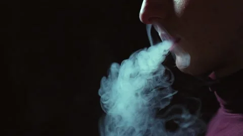Man smokes an electronic cigarette in the dark. Vape. Stock Footage 236255149