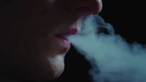 Man smokes an electronic cigarette in the dark. Vape. Stock Footage 236255150