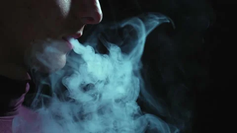 Man smokes an electronic cigarette in the dark. Vape. Stock Footage 236255335