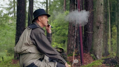 Man smokes by the fire. Smoke from electronic cigarette Stock Footage 141256609