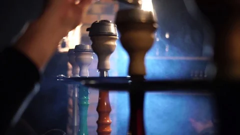 Man smokes a hookah and adjusts the coal in the bowl. slow motion Stock Footage 87247182