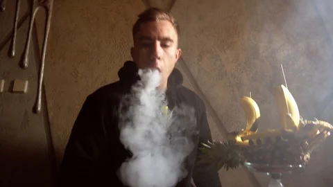 Man smokes a hookah in a bar Stock Footage 122951485