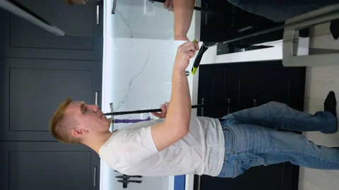 Man Smokes Hookah in Kitchen. Prepares Dinner Himself. Stir Food in Frying Pan Stock Footage 147348722