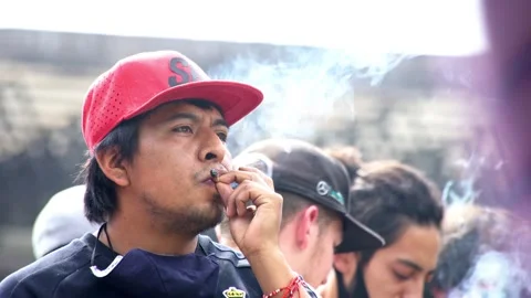 A man smokes a joint of weed during a protest Stock Footage 139470885