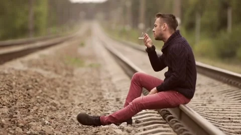 Man smokes on the rails. Stock Footage 67853839