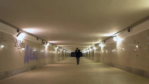 A man smokes in an underground passage Видео 81595663