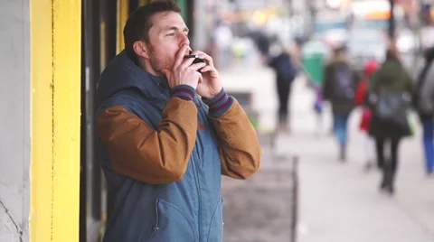 A man smokes while talking on the phone Stock Footage 62814970