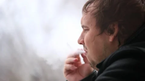 Man smoking cigarette and looking in the window. He coughs but continues to Stock Footage 47558103
