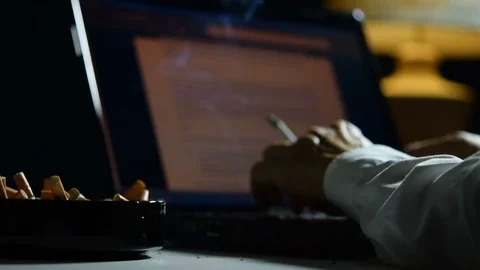 Man smoking cigarette and working on a laptop computer . Vidéo 125543300