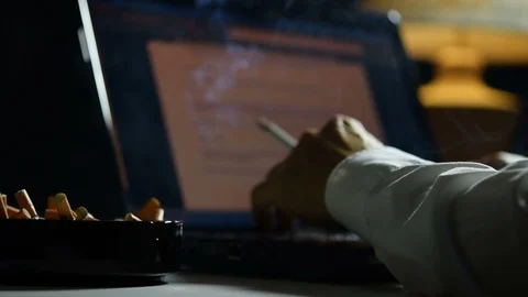 Man smoking cigarette and working on a laptop computer . Stock Footage 125543306