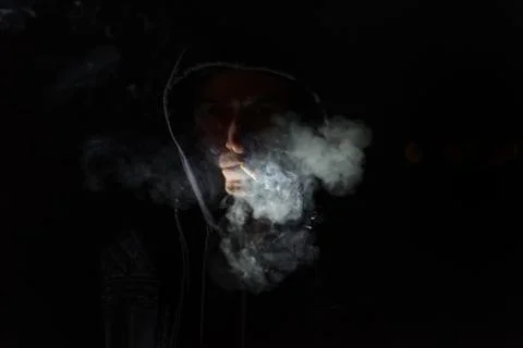 Man is smoking a cigarette on black background Stock-Fotos