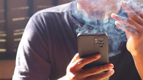 Man smoking cigarette while using smartphone Stock-Footage 334049259