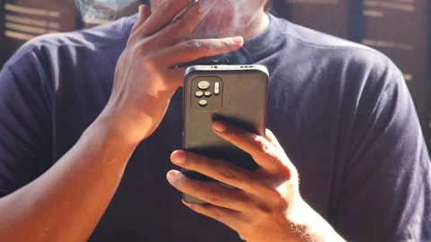 Man smoking cigarette while using smartphone Stock-Footage 334049310