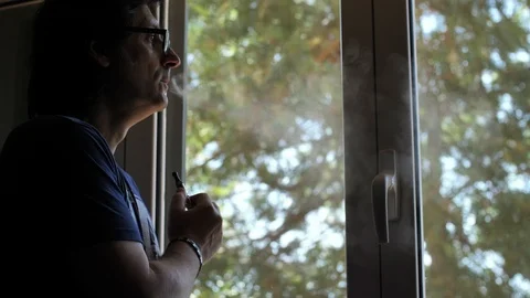 Man smoking e-cigarette next to window. cinemagraph Stock Footage 119222519