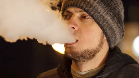 Man smoking e-cigarette outdoor at night Stock Footage 61865529