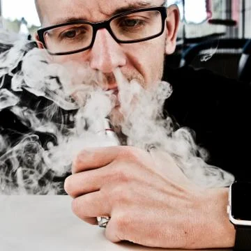 Man smoking electronic cigarette Stock Photos