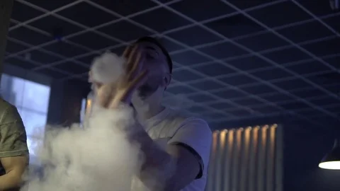 Man is smoking a hookah in the dark 스톡 동영상 85187420