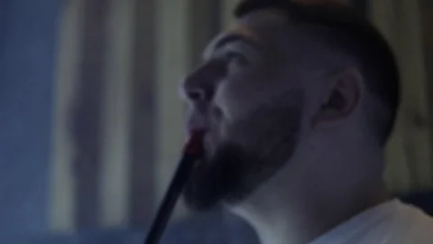 Man is smoking a hookah in the dark Vídeo Stock 85187661