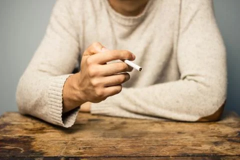 Man smoking at table Photos