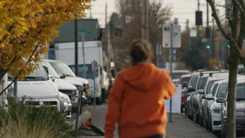 Man smoking a vape while walking down a city sidewalk on a fall day Stock Footage 120003338