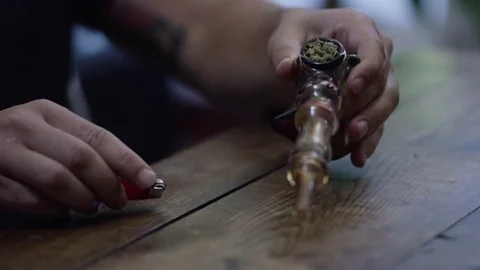 Man Smoking Weed from a Pipe/Bubbler Stock Footage 73096574