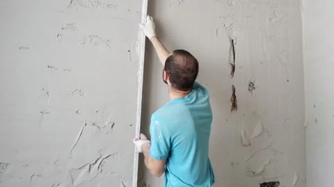 Man Smooths Out Plaster On Wall. Neatly Leads Level up. Wall. Plasterer at Work Stock Footage 168356251