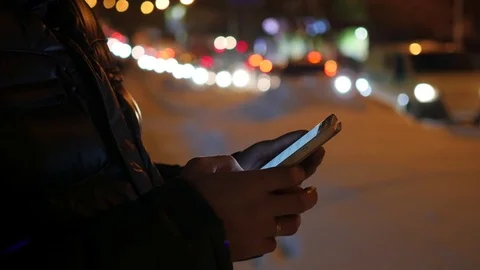 Man sms texting using app on smartphone at night in city, winter time Vidéo 69978263