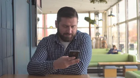 Man sms texting using app on smart phone in cafe, steadicam shot  Vídeos de archivo 72951077