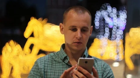 Man sms texting using app on smart phone at night in city. Handsome young Stock Footage 76638276