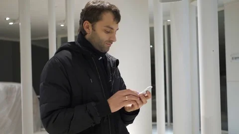 Man sms texting using app on smart phone at night in city. Handsome young Stock Footage 82336828