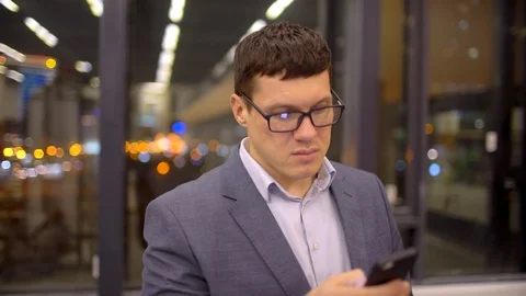 Man sms texting using app on smart phone at night in city. Handsome young Stock Footage 87194492